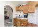 Functional kitchen with double sink, wood cabinets, and a view into the living area at 715 S Ribble Ave, Muncie, IN 47302