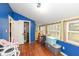 Bedroom featuring blue walls and hardwood floors, offering a unique design with plenty of natural light at 7971 Conarroe Rd, Indianapolis, IN 46278
