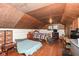 Attic bedroom with wood floors, a striped bed, and a unique angled ceiling at 7971 Conarroe Rd, Indianapolis, IN 46278