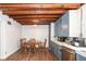 Dining room features exposed wood beams, wooden floors and a table set for four at 7971 Conarroe Rd, Indianapolis, IN 46278