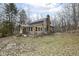 Rustic cabin exterior with stone chimney and wooded surroundings, giving a rural, tranquil impression at 7971 Conarroe Rd, Indianapolis, IN 46278