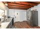 Kitchen with blue cabinets, stainless steel appliances, and exposed beams, combining rustic and modern elements at 7971 Conarroe Rd, Indianapolis, IN 46278