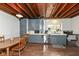 Cozy kitchen featuring exposed wood beams, blue cabinets, wood floors and stainless steel appliances at 7971 Conarroe Rd, Indianapolis, IN 46278