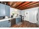 Functional kitchen with blue cabinetry, stainless steel appliances, and hardwood floors offering a cozy feel at 7971 Conarroe Rd, Indianapolis, IN 46278