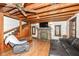 Living room showcasing a stone fireplace, hardwood floors, wood beam ceiling and staircase to the upper level at 7971 Conarroe Rd, Indianapolis, IN 46278
