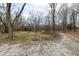 Gravel driveway leading into a wooded lot with a clearing, suggesting privacy and natural beauty at 7971 Conarroe Rd, Indianapolis, IN 46278