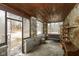 Enclosed sunroom with stone walls, wood ceiling, and plenty of natural light at 7971 Conarroe Rd, Indianapolis, IN 46278