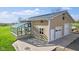 Exterior view of the garage with white doors, greenhouse, and a concrete apron at 800 N 400 W, Bargersville, IN 46106