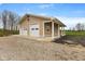 Exterior view of the garage with two white doors, a covered porch, and gravel driveway at 800 N 400 W, Bargersville, IN 46106