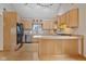 Well-lit kitchen with wooden cabinets, stainless steel appliances, and an island with cooktop at 800 N 400 W, Bargersville, IN 46106