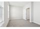 An empty bedroom with neutral carpet and white walls featuring windows and a door at 848 Kinzer Ave, Carmel, IN 46032
