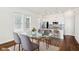 Bright dining area with a glass-top table, modern chairs, and a view into the adjacent kitchen with stainless appliances at 848 Kinzer Ave, Carmel, IN 46032