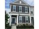 Charming two-story townhome featuring a dark-blue front door, large windows, black shutters, and a well-maintained lawn at 848 Kinzer Ave, Carmel, IN 46032