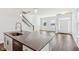 Kitchen island with sink overlooking an open concept living area with hardwood floors and staircase at 848 Kinzer Ave, Carmel, IN 46032