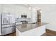 Bright kitchen with stainless steel appliances, gray backsplash, kitchen island, and hardwood flooring at 848 Kinzer Ave, Carmel, IN 46032