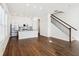 Open-concept living room featuring hardwood flooring, abundant natural light, and stairs with dark metal banisters at 848 Kinzer Ave, Carmel, IN 46032