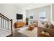 Cozy living room showcasing modern furnishings, neutral color palette, hardwood floors, and staircase with wooden banister at 848 Kinzer Ave, Carmel, IN 46032