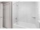 Bathroom features a white tub with a shower head, and white marble-style tiles at 8825 Dunsmuir Dr, Indianapolis, IN 46260