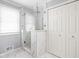 Bathroom with a glass walk-in shower featuring marble surround and white tile at 8825 Dunsmuir Dr, Indianapolis, IN 46260