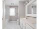 Bright bathroom with double sinks, white cabinets, and a shower with marble-style tiles at 8825 Dunsmuir Dr, Indianapolis, IN 46260