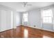 Bright bedroom featuring hardwood floors, two windows with white curtains, and a closet with white doors at 8825 Dunsmuir Dr, Indianapolis, IN 46260
