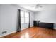Bedroom features hardwood floors, a window with dark curtains, and black dressers at 8825 Dunsmuir Dr, Indianapolis, IN 46260