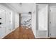 Inviting entryway with hardwood floors, built-in bench, and views into dining room at 8825 Dunsmuir Dr, Indianapolis, IN 46260