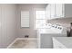 A bright laundry room featuring a washer and dryer, white cabinets, and tile floors at 8825 Dunsmuir Dr, Indianapolis, IN 46260