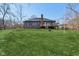 Large, well-maintained backyard with a deck, patio, and mature trees in the background at 901 Detroit St, Beech Grove, IN 46107