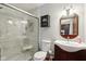 Bathroom with a glass shower, dark vanity with white sink, and a round mirror at 901 Detroit St, Beech Grove, IN 46107
