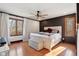 Bright bedroom with hardwood floors, a ceiling fan, and a large window overlooking a wooded area at 901 Detroit St, Beech Grove, IN 46107
