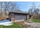 Close up of attached two car garage with brick facade, short driveway, and neat landscaping at 901 Detroit St, Beech Grove, IN 46107