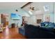 Spacious living room with a vaulted ceiling, brick fireplace, skylights, and wood laminate flooring at 901 Detroit St, Beech Grove, IN 46107