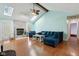 Bright living room features a brick fireplace, vaulted ceiling with skylights, and wood laminate flooring at 901 Detroit St, Beech Grove, IN 46107