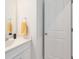 Bathroom featuring a white vanity with a sink, a door, and a towel ring with a yellow towel at 9658 Farragut, Indianapolis, IN 46256