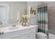 Well-lit bathroom with a modern vanity, decorative mirror, and stylish shower curtain at 9658 Farragut, Indianapolis, IN 46256