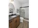 Stylish bathroom featuring a sleek vanity, a large round mirror and a glass-enclosed shower at 9658 Farragut, Indianapolis, IN 46256