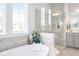 Bathroom featuring a glass-enclosed shower, large tub, and a view from the window at 9658 Farragut, Indianapolis, IN 46256