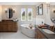 Bright bathroom with a soaking tub, double vanity, and modern fixtures at 9658 Farragut, Indianapolis, IN 46256