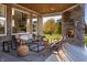 Inviting covered patio featuring a stone fireplace, comfortable seating, and views of the landscaped backyard at 9658 Farragut, Indianapolis, IN 46256