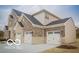 Stylish two-story home with an attached three-car garage featuring stone and brick accents at 9658 Farragut, Indianapolis, IN 46256