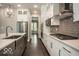 Bright kitchen featuring white cabinets, gray backsplash, stainless steel appliances, and modern countertops at 9658 Farragut, Indianapolis, IN 46256
