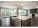 Open-concept kitchen with island, stainless steel appliances, and view into the living area with fireplace at 9658 Farragut, Indianapolis, IN 46256