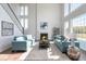 Bright living room with high ceilings, fireplace, large windows, and comfortable turquoise sofas at 9658 Farragut, Indianapolis, IN 46256