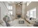 Open living room featuring a stone fireplace, high ceilings, and large windows at 9658 Farragut, Indianapolis, IN 46256