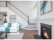 Living room with a fireplace, staircase, large windows, and hardwood floors with a patterned rug at 9658 Farragut, Indianapolis, IN 46256