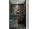 Luxurious walk-in shower with black marble tiles, dual shower heads, and glass door at 9658 Farragut, Indianapolis, IN 46256