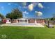 Backyard view of a brick house with a covered pool and a shed against a backdrop of blue sky and green grass at 1002 Payton Ave, Indianapolis, IN 46219