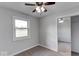 This bedroom has carpet, a ceiling fan, one window, and a closet with mirrored doors at 1002 Payton Ave, Indianapolis, IN 46219