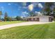 A lovely single-story brick home featuring an attached garage, manicured lawn, and extended driveway at 1002 Payton Ave, Indianapolis, IN 46219